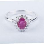A RUBY AND DIAMOND RING centred with an oval mixed-cut ruby weighing approximately 0.52cts, the