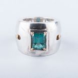 AN EMERALD RING, ORPHEO the broad band with cut-out detail, tube set with an emerald-cut emerald