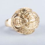A GOLD RING the gold, fashioned as layers of feathers, in a dome in 18k yellow gold, impressed