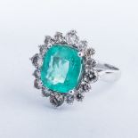 AN EMERALD AND DIAMOND RING the 4.37ct cushion cut emerald claw-set and surrounded by 16 round