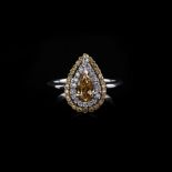 A DIAMOND RING the centre pear shape diamond weighing 0.605ct colour vivid fancy brownish yellow,