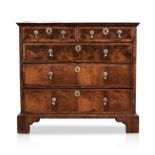 A GEORGE III WALNUT CHEST OF DRAWERS the rectangular quarter veneered and cross banded top above a