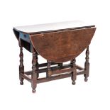 AN OAK GATE LEG TABLE, EARLY 19TH CENTURY the hinged oval top above a short frieze drawer, on