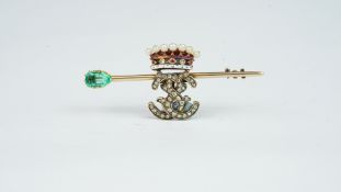 Gem set brooch, diamond set monogram, beneath an enamel and pearl crown, on a yellow metal bar,