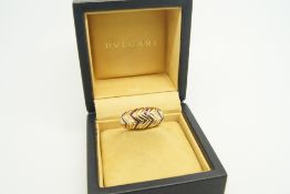 Bulgari ring, round cut rubies, set in zig-zag lines, spaced in a similarly designed gold band,