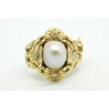Pearl and diamond ring, central 8 x 10mm pearl, in a yellow metal mount, designed as flowers and