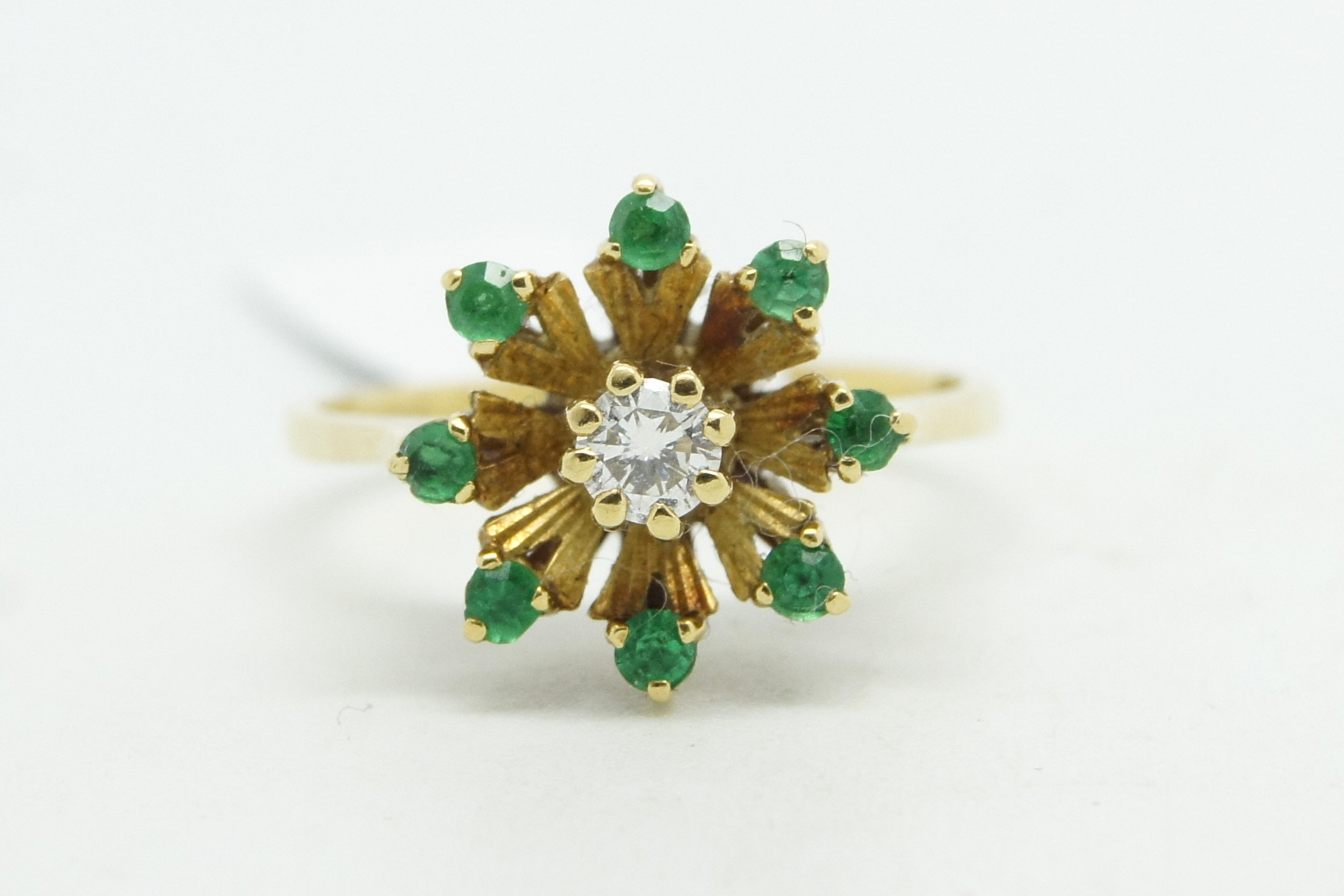Emerald and diamond cluster ring, central round brilliant cut diamond, surrounded by round cut