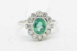 Emerald and diamond cluster ring, central oval emerald weighing an estimated 1.20ct, surrounded by