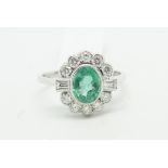 Emerald and diamond cluster ring, central oval emerald weighing an estimated 1.20ct, surrounded by