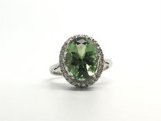 Green tourmaline and diamond ring, oval pale green tourmaline surrounded by round brilliant cut