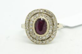 Ruby and diamond cluster ring, central oval cut ruby with a double surround of Swiss cut diamonds,