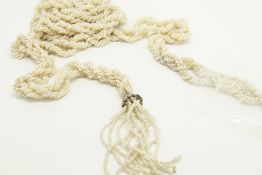 Twisted seed pearl lariat style necklace, each end is terminated by seed pearl tassels, suspended