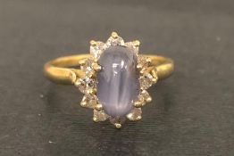 Star sapphire and diamond ring, central oval cabochon cut star sapphire, surrounded by round