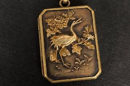 Shokudo locket set with a bird on one side and a fan on the other side, measuring approximately 32 x