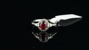 Ruby and diamond cluster ring, central oval cut ruby, surrounded by round brilliant cut diamonds,
