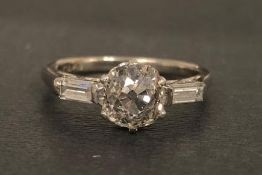 Diamond ring, central old cut diamond measuring an estimated 6 x 6mm, with a baguette cut diamond to