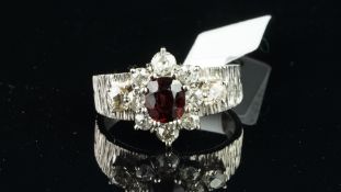 Garnet and diamond ring, central cushion cut garnet, surrounded by old cut diamonds, set in white