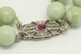 Two row jade bead necklace, beads measure an estimated 9mm, on a ruby and diamond set clasp