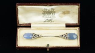 Onyx, diamond and chalcedony jabot pin, each end terminated by an oval blue chalcedony, with an onyx