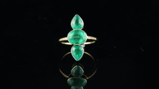 Three stone emerald ring, central horizontally set oval cut emerald, with a pearl cut emerald