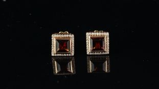 A pair of garnet and diamond earrings, square cut garnet, surrounded by round brilliant cut