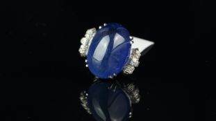 A large sapphire and diamond ring, sugarloaf cabochon cut blue sapphire weighing an estimated 42.