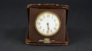 Eight day travel clock, porcelain dial with luminous Arabic numeral hour markers and cathedral style