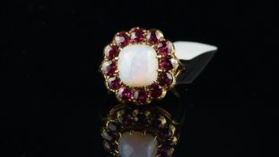 Opal and ruby ring, central cabochon cut opal, surrounded by round cut rubies, in yellow metal