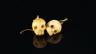 A pair of bone earrings in the form of skulls