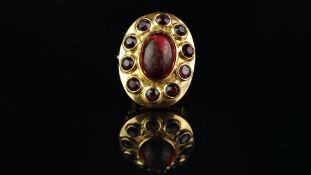 Garnet cluster ring, central oval cabochon, surrounded by round faceted garnets, mounted in yellow