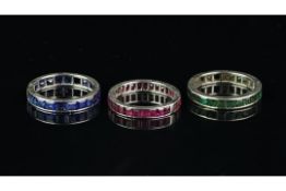 Three full eternity rings, one set with rubies, one sapphires, one emeralds, mounted in platinum,