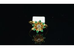 Emerald and diamond cluster ring, central round brilliant cut diamond, surrounded by round cut