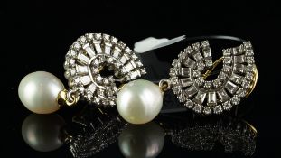 A pair of diamond and pearl earrings, round brilliant cut and baguette cut diamonds, in a swirl