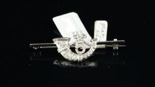 Diamond brooch, designed as a horn and bow, with the number 5, mounted in platinum