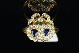 A sapphire and diamond double heart and cluster ring, set with two pear shape sapphires,