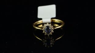 Sapphire and diamond cluster ring, central oval cut sapphire, surrounded by round brilliant cut