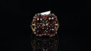 A late Georgian rose-cut garnet cluster ring, with square top, on a plain split shouldered shank,