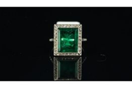 A green paste ring in a white metal mount with a halo of white stones, ring size J 1/2