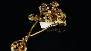 A Victorian garnet brooch, set with cabochon cut garnets set in a floral motif, suspending another