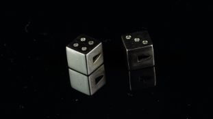 A pair of 9ct white gold diamond set dice pendants, one with three diamond dots and one with four,