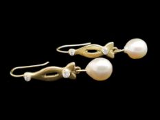 A pair of pearl and diamond drop earrings, set with two round brilliant cut diamonds, in a twist