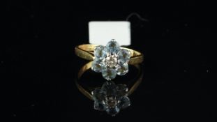 An aquamarine and diamond cluster ring, one aquamarine is chipped, mounted in yellow metal stamped