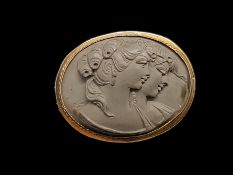 A lava cameo brooch, depicting the profile of two females, in a yellow metal border, tested as 9ct