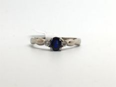 Three stone sapphire and diamond ring, central oval cut sapphire, with a diamond set to each side,