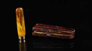 Amber charoot, with a gold plated end, signed H.C, in a fitted box