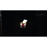 Three stone ruby and diamond ring, central ruby weighing an estimated 1.50ct, with a round brilliant