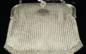 Silver purse, chainmail design with tassel detail, suspending a silver George V Sixpence
