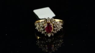 Ruby and diamond cluster ring, central oval cut ruby in a floral tiered diamond surround, mounted in