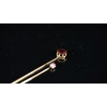 Two stick pins, one set with an old cut almandine garnet, the other set with a cushion cut ruby,