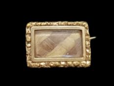 A Victorian memorial brooch, central rectangular hair compartment with engraved gold border, mounted
